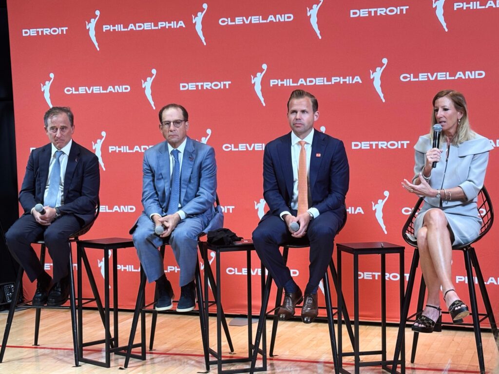 wnba-owners-announcement-ap-2025-06-30 Various officials sitting on stools on a stage during a press conference