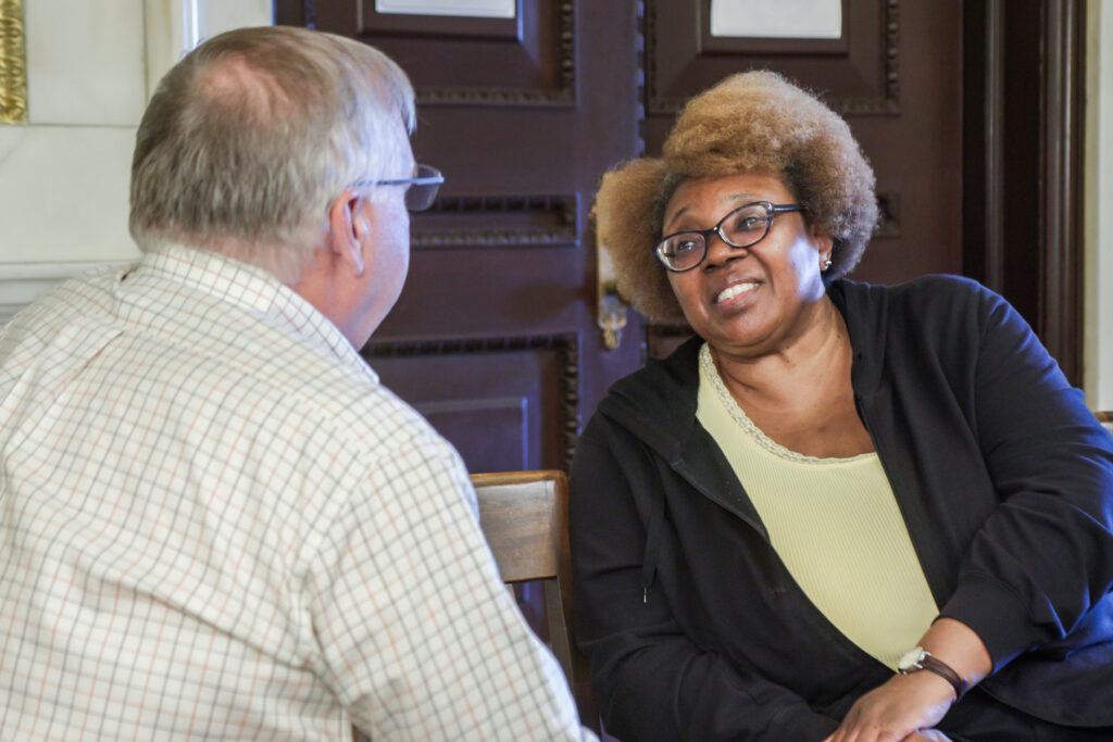 Two people sitting talking inside city hall