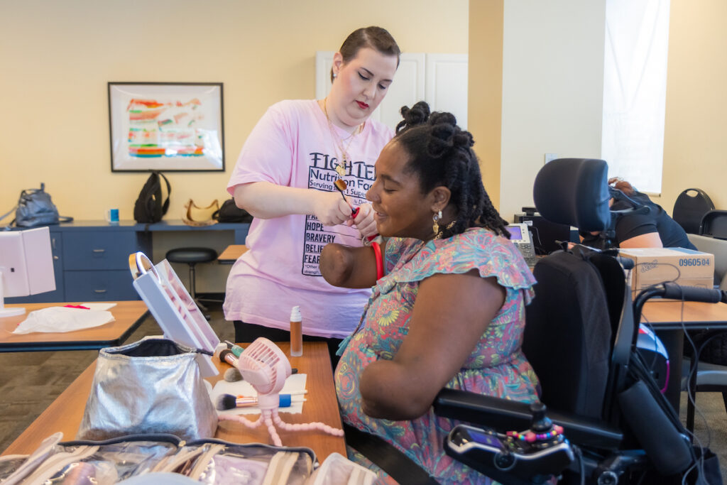 07 28 2025 k paynter jefferson rehab support group-2 Rebecca Carpino (left) helps Candice Davis (right) align a makeup brush