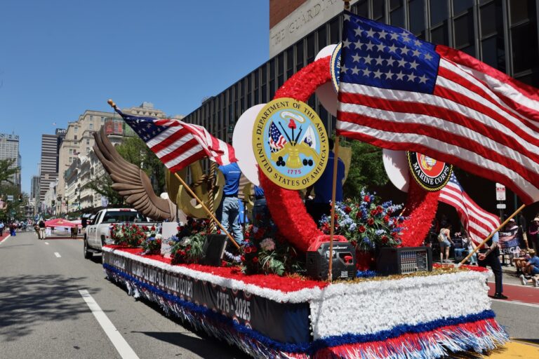 A large parade float drives down Market Street in Philadelphia