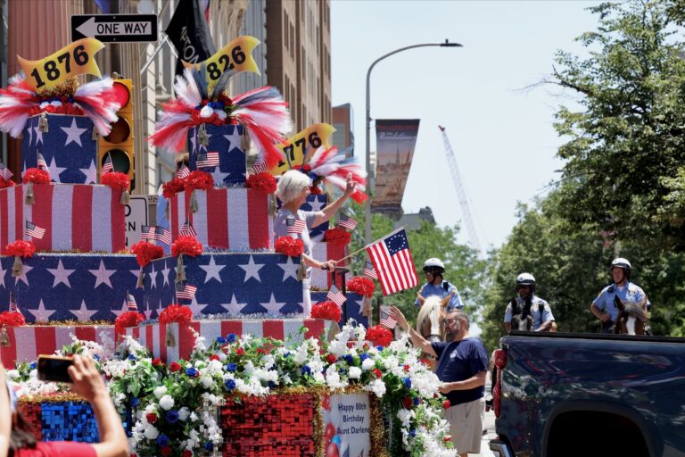 A large parade float with an American-themed birthday cake in downtown Philadelphia.