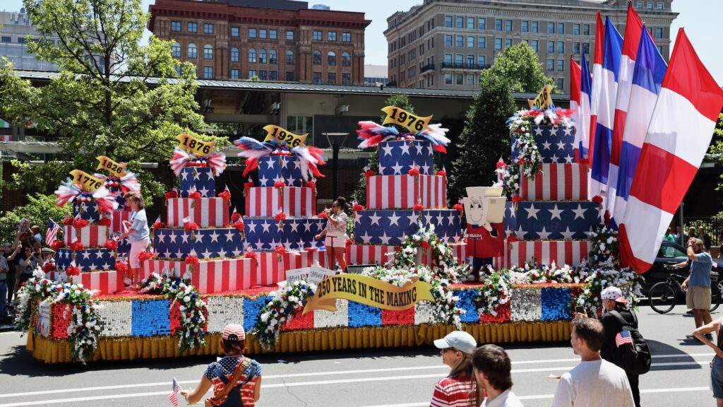 A large float with an American-themed birthday cake drives in downtown Philadelphia during the Fourth of July parade.