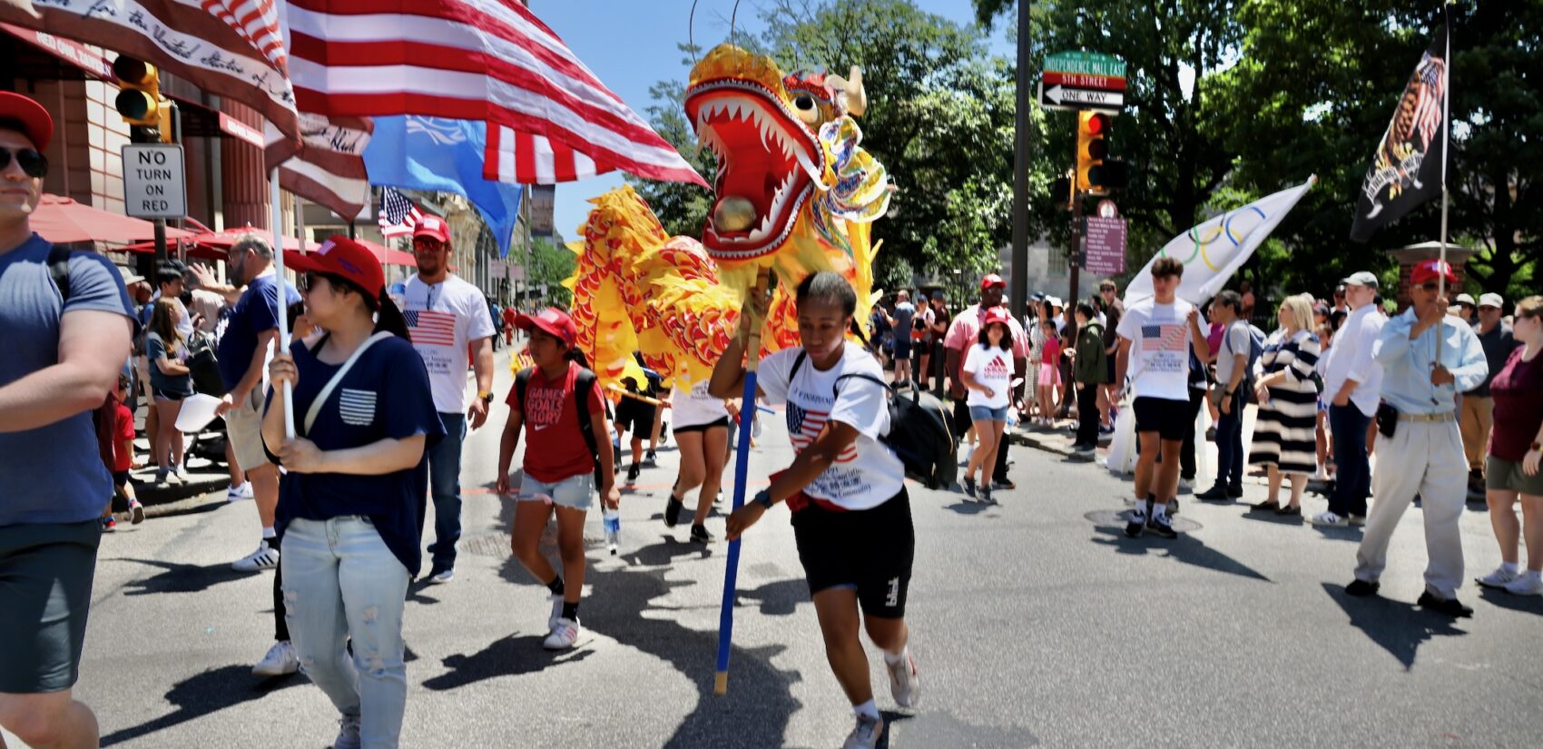 People raise a large dragon puppet as part of Philadelphia's Fourth of July parade.