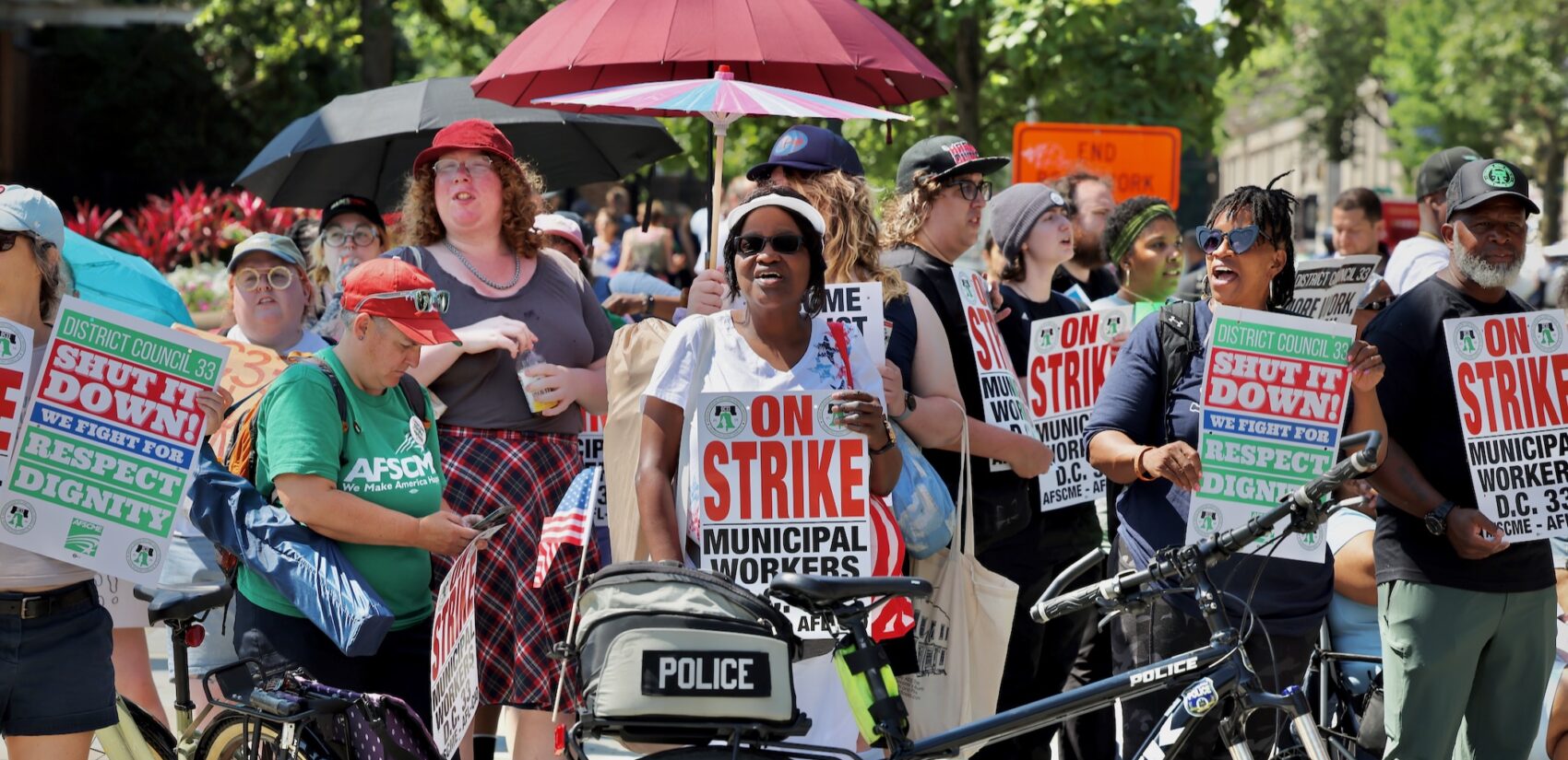 Striking Philadelphia municipal workers carry signs and chant during Philadelphia's Fourth of July parade.