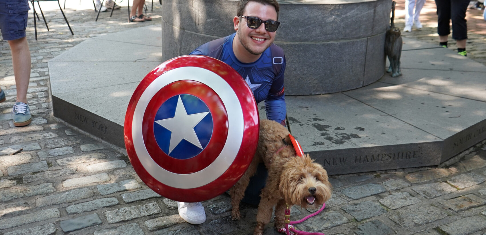 A man dressed as Captain America and his dog