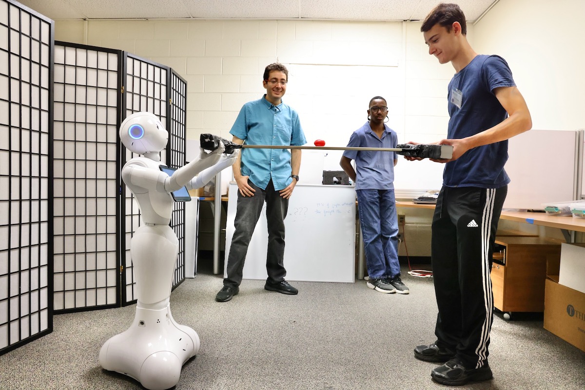 Kolton Thomsen works cooperatively with a robot named Pepper