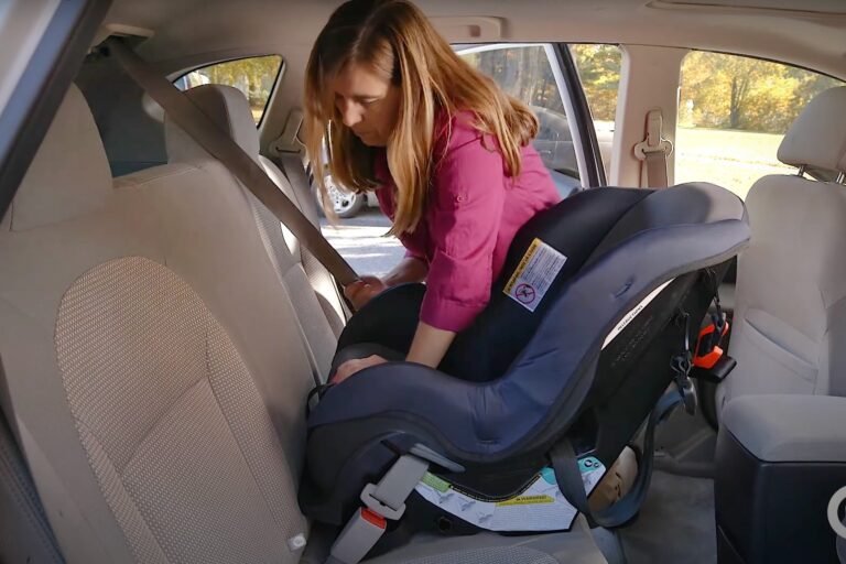 A woman putting a child into a car seat