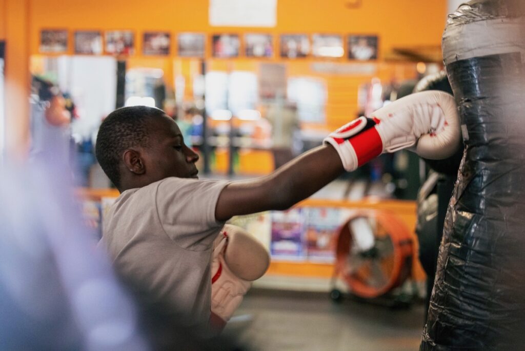 2025 07 24-r chi-aaron geddes-trenton nj ike williams boxing academy-guns down gloves up bag Aaron Geddes punching a heavy bag at the Ike Williams Boxing Academy in Trenton. New Jersey