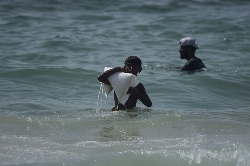 APTOPIX Israel Palestinians A Palestinian youth carries a sack of aid that landed in the Mediterranean Sea after being airdropped over central Gaza, at the shore of Zawaida, Gaza Strip Tuesday, July 29, 2025. (AP Photo/Abdel Kareem Hana)