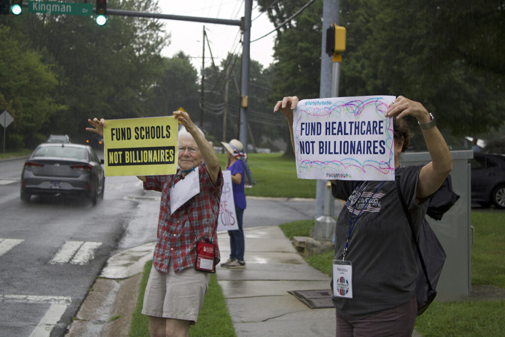 Protest 7_26_2 copy People hold up signs protest cuts to Medicaid