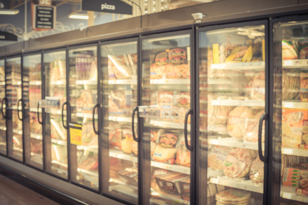 Blurry background frozen pizza in freezer at American supermarket
