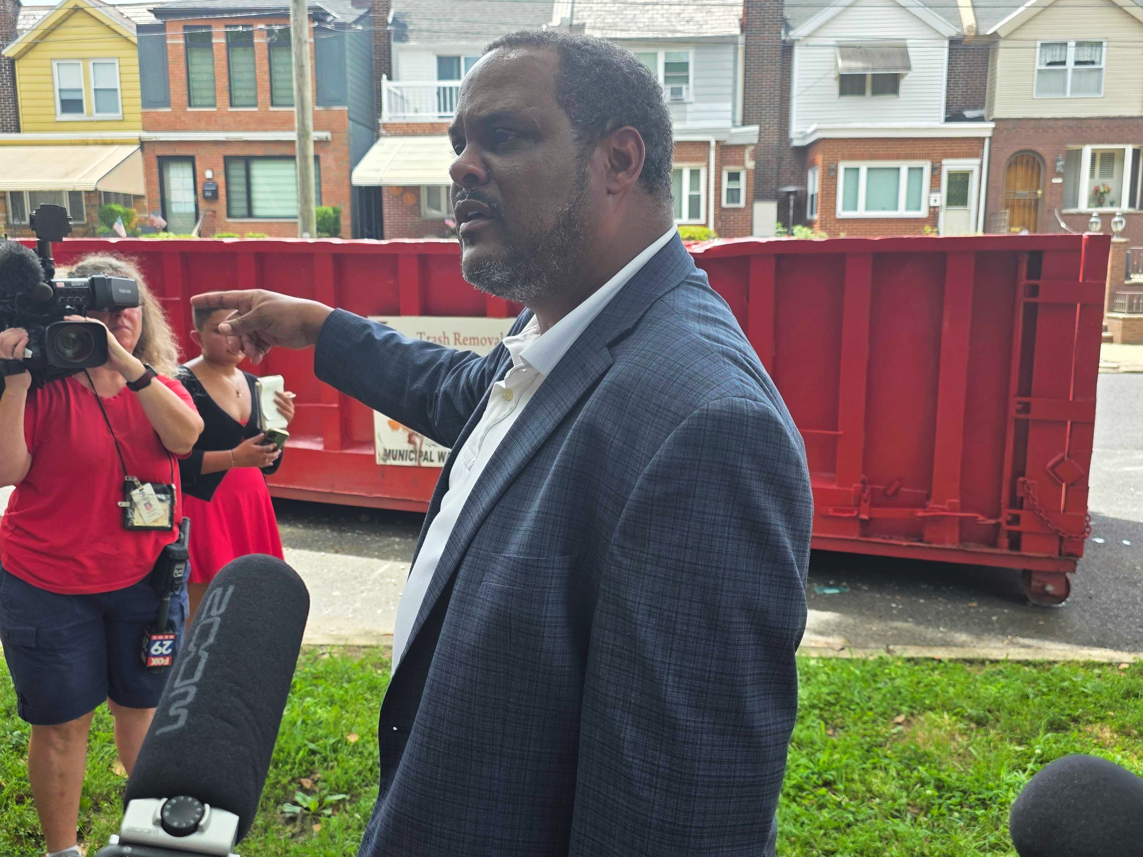 Carlton Williams points to a dumpster