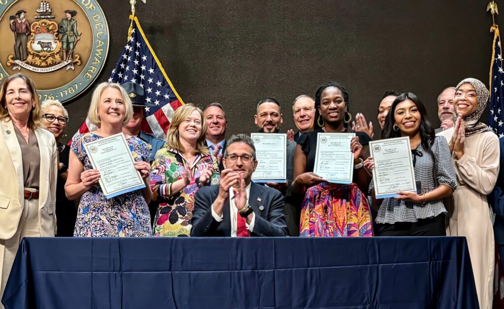 delaware-governor-meyer-signs-ice-legislation-2025-07-14 Delaware state lawmakers holding signed ICE bills