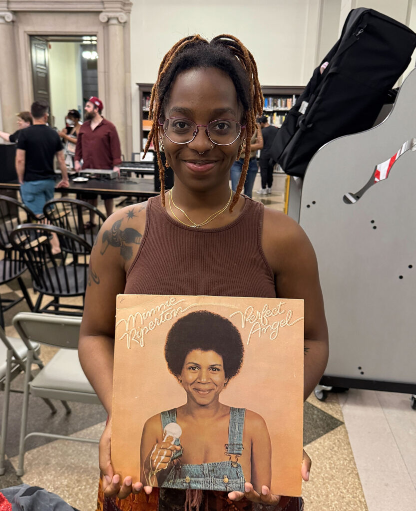 A woman holds a vinyl record of "Perfect Angel" by singer Minnie Riperton