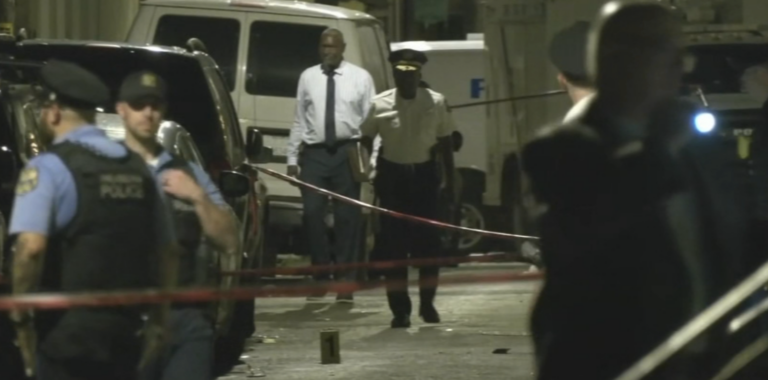 Police comb the scene of a mass shooting in Grays Ferry