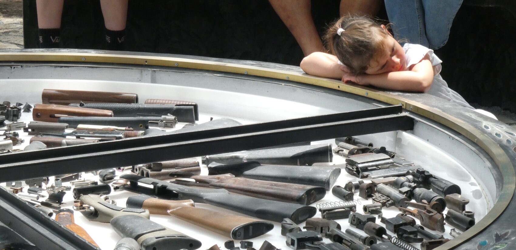 a child rests their head on the Gun Violence Memorial Sculpture