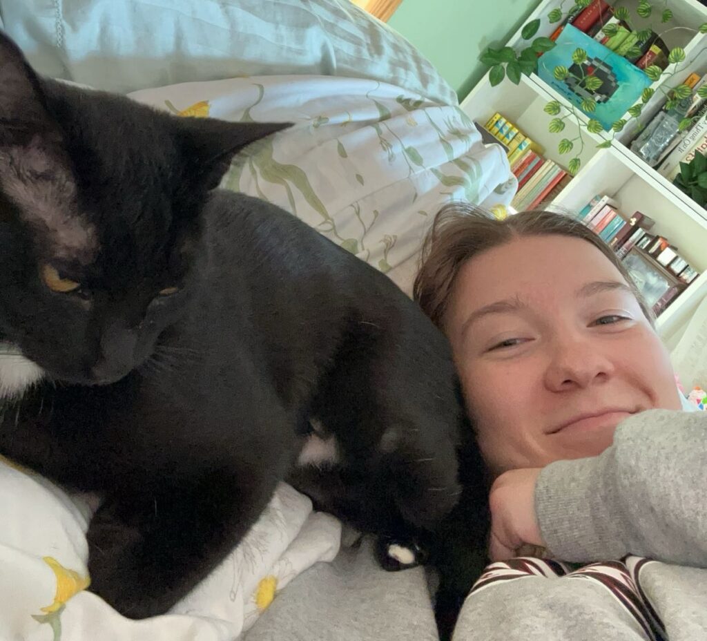Gwen lying in bed with her cat