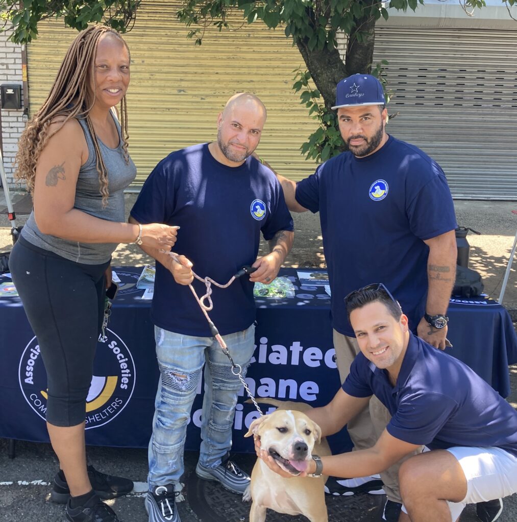 Several people posing for a photo with a dog
