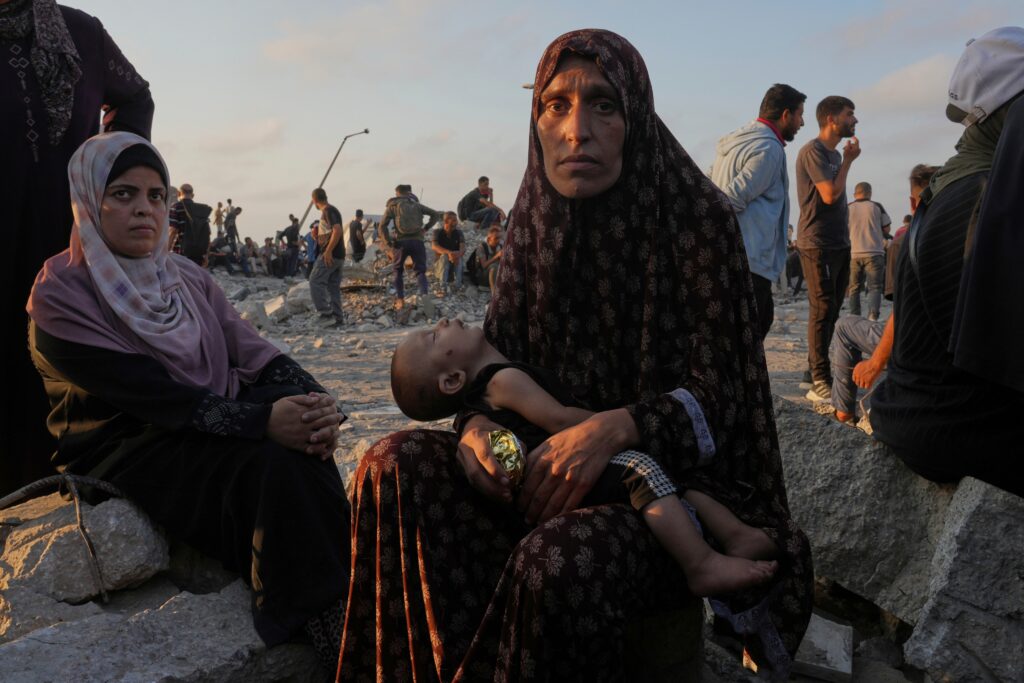northern-gaza-strip-ap-2025-07-25 Somoud Wahdan looks at the camera as she sits with her child