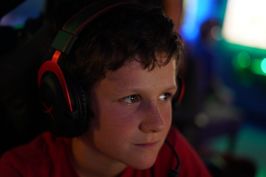 oscar-lasko-ymca-k-cooper-2025-07-16-1 A boy wearing headphones watches his video game intently