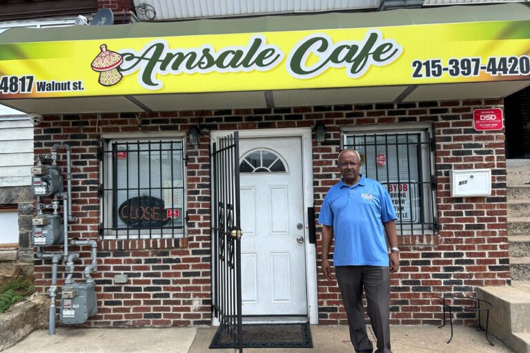 A man stands outside his business, Amsale Cafe, in West Philadelphia.