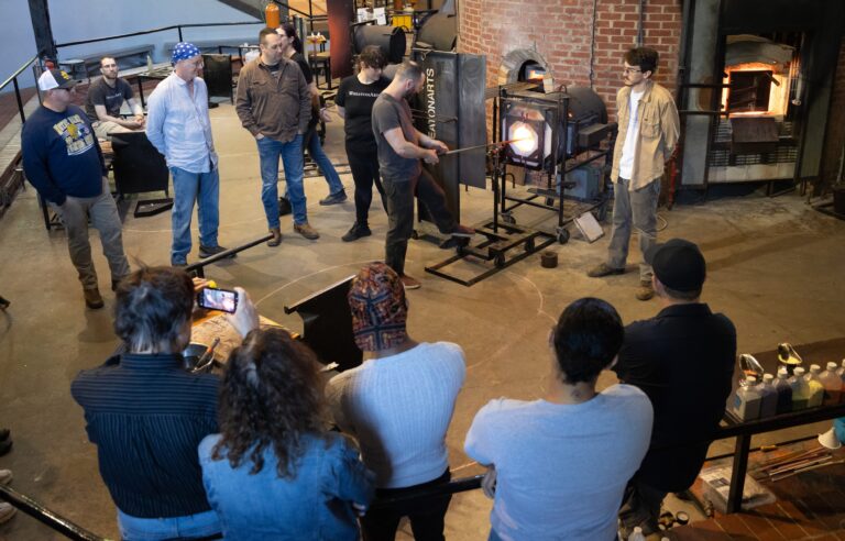 A class at WheatonArts gets a lesson on glass blowing