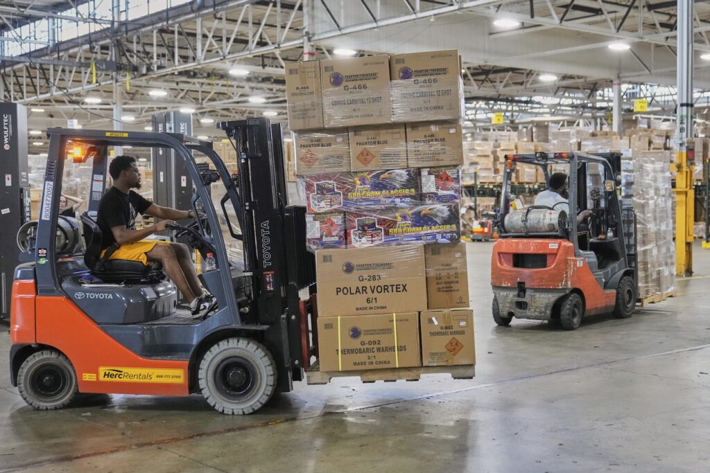 A worker carries a shipment on a forklift