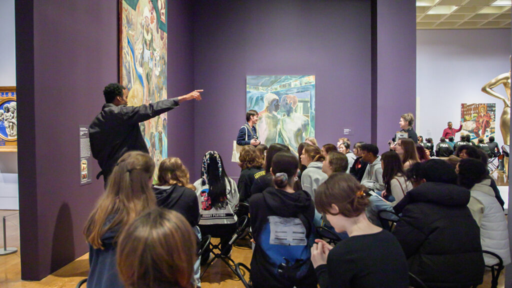12-13-2024-k-paynter-free-museum-busing-3 Students listen to a speaker in the museum