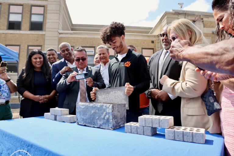 Nilsa Cruz with students holding up an item from the time capsule