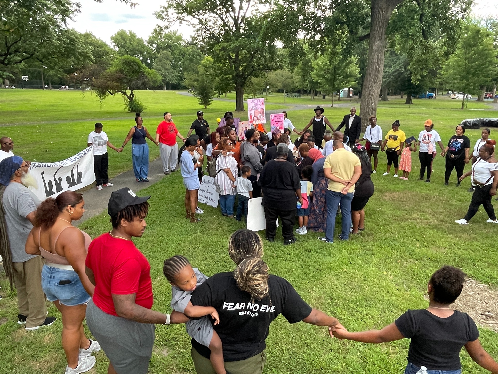 Supporters of the Waheed family form a circle around them at Farnham Park