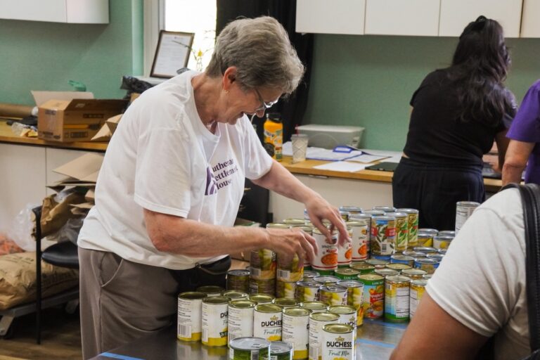 Chris McReynolds restocking a table at Lutheran Settlement House