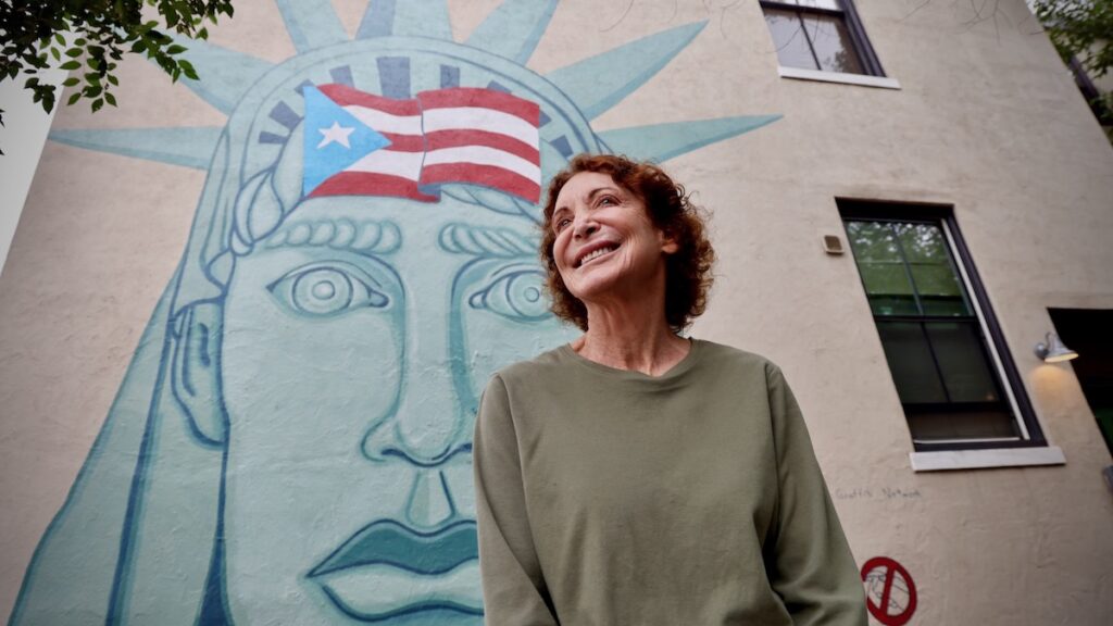Jane Golden poses in front of her first murals