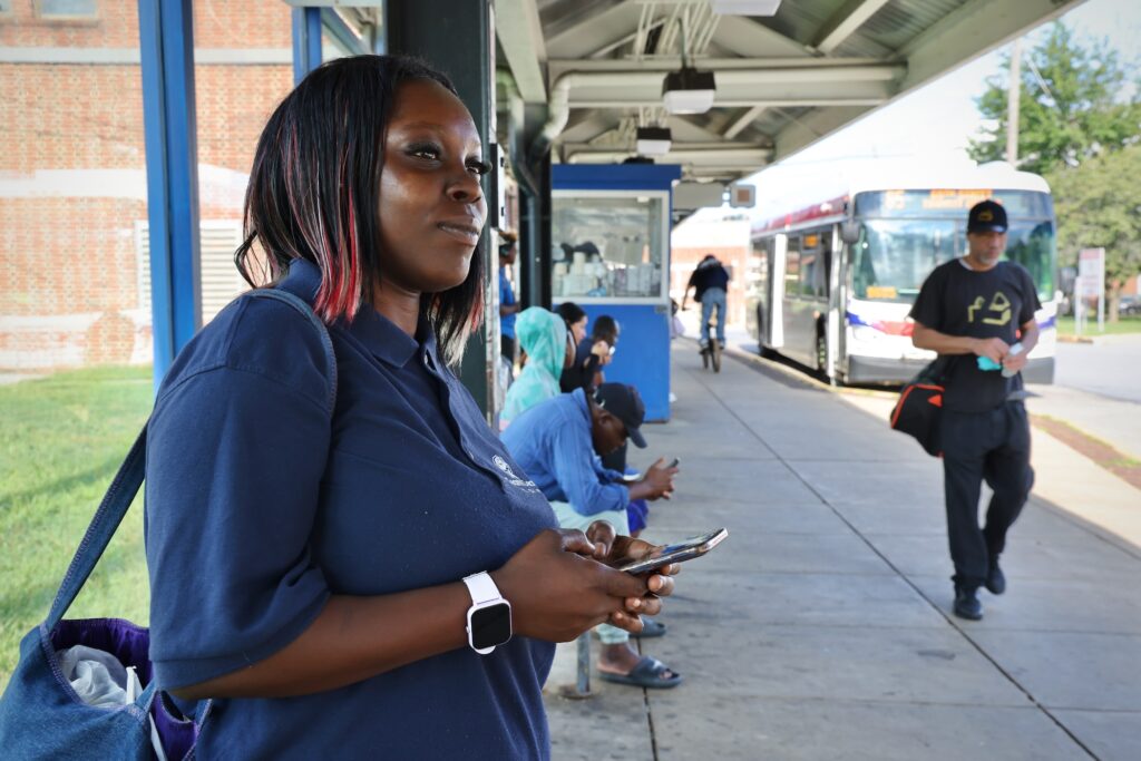 A woman waiting for a bus the bus terminal