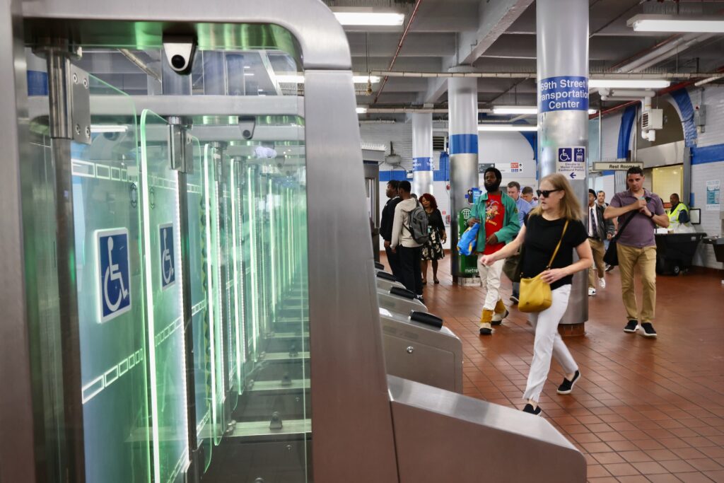 People approaching the turnstiles to enter the station