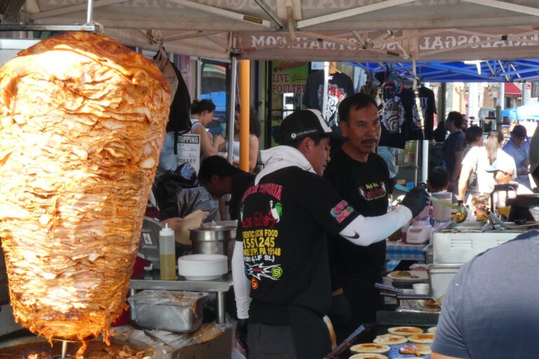 gyro meat and two people cooking food