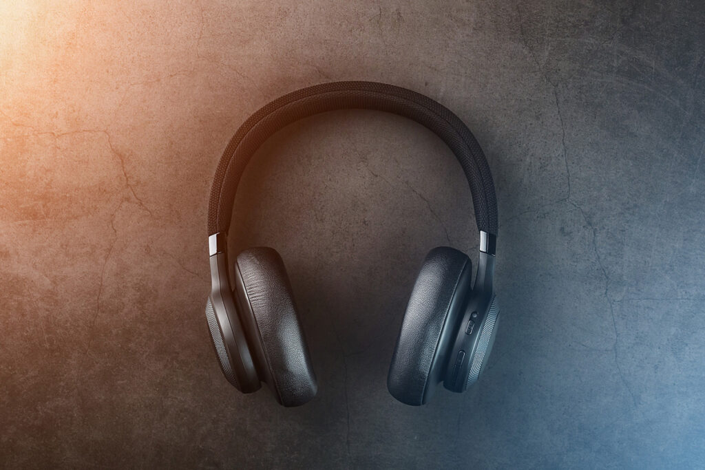 Black Wireless Headphones On A Black, Stone Background With A Go Over a billion young people are at risk of hearing loss in part due to headphone use. (Bigstock/alexgrec)