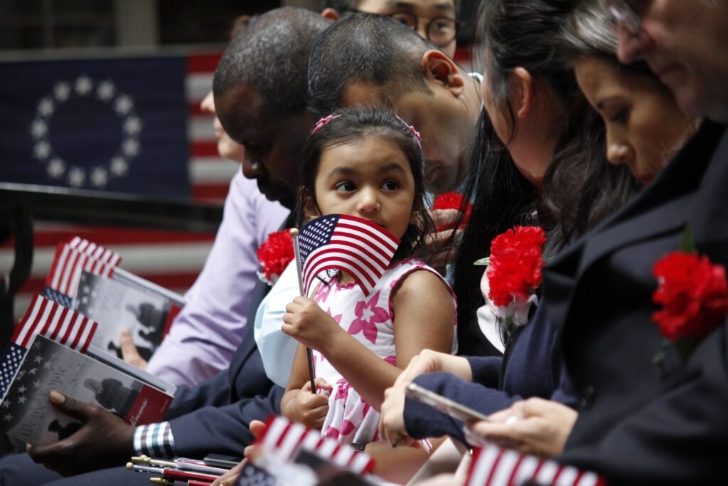 Immigration US a yung girl waves a small American Flag during the ceremony