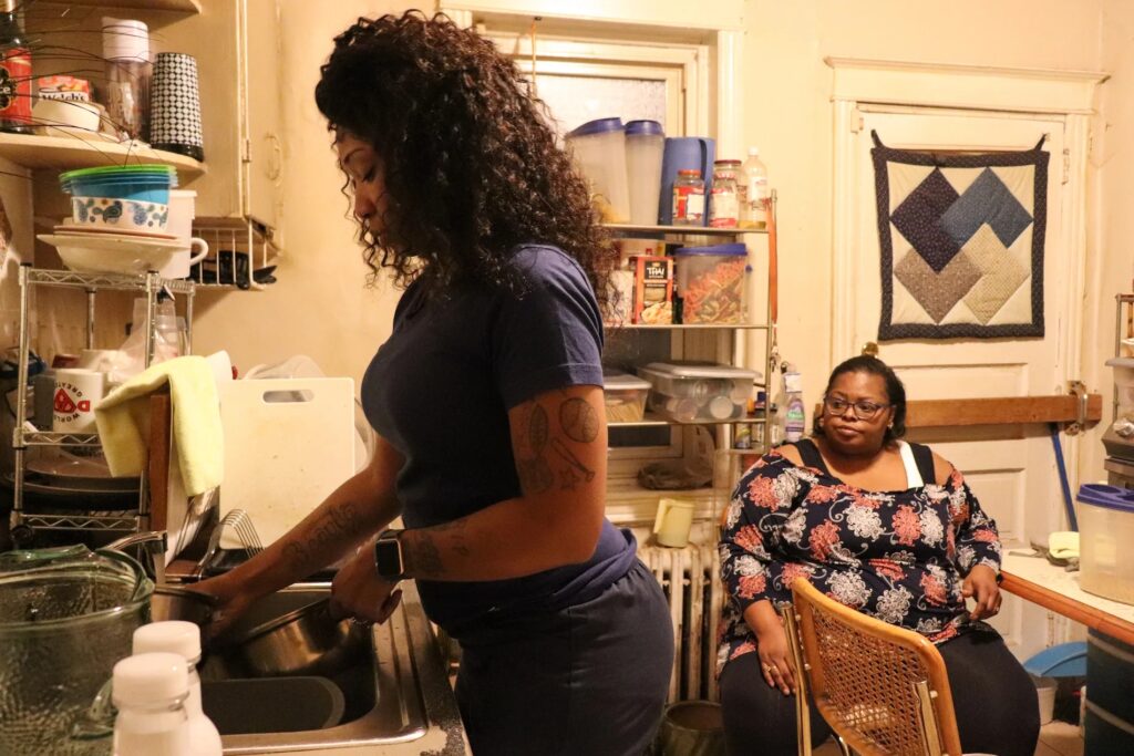 Karas_HomeHealthWHYY-18-file Jasmine Henderson, a home health aide, washes dishes as Altonya Sheppard looks on