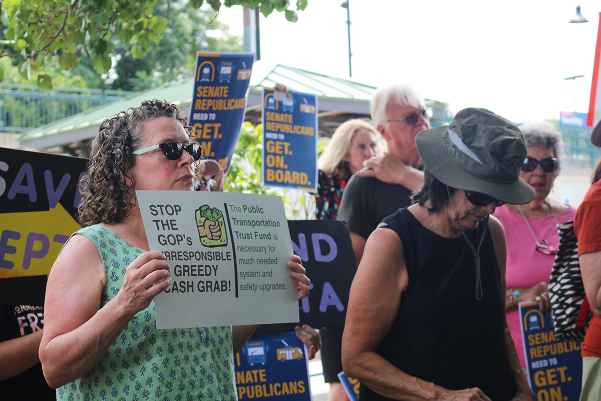 Bucks County residents hold signs at a SEPTA funding rally