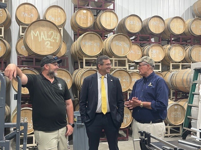 chip matt chuck in barrel room Delaware Gov. Matt Meyer talks with two men at a winery with barrels in the background