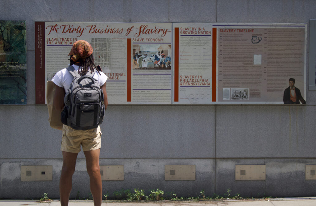 dirty-business-of-slavery-exhibit-philadelphia A visitor at Independence National Historical Park stands in front of an exhibit reading The Dirty Business of Slavery