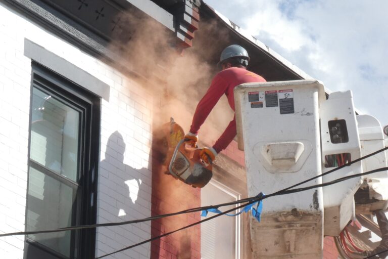 a worker attending to a collapsed Philadelphia house
