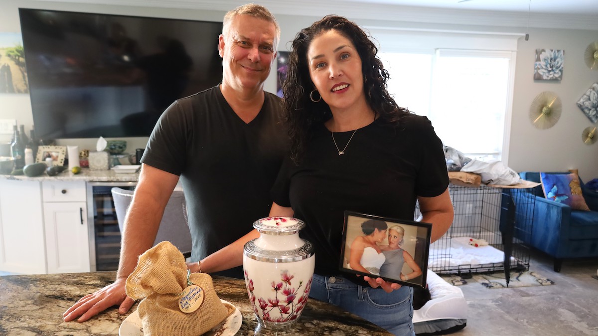 Jayme Strasburger with husband Jason, holding picture of mother