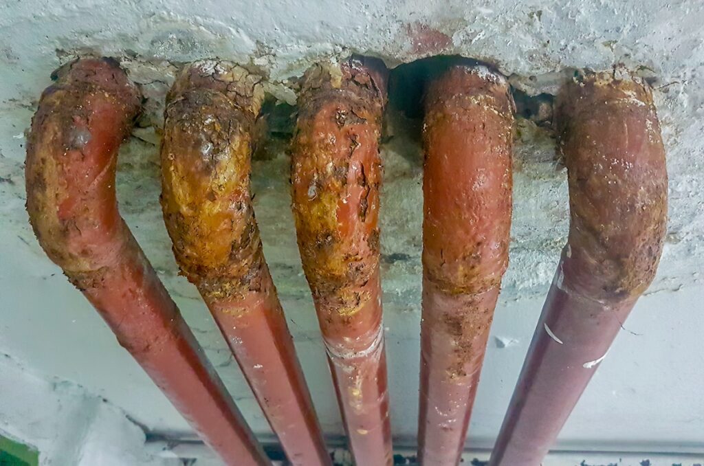 several old lead pipes in a wall several old lead pipes in a wall