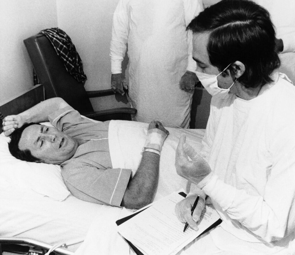 Legionnaires Disease Dr. Stephen Thacker, right, of the U.S. Center for Disease Control, interviews Thomas Payne in Chambersburg Hospital in Pennsylvania, Aug. 4, 1976. Payne was one of the Legionnaires who became ill after attending a state convention in Philadelphia. (AP Photo/Pool)