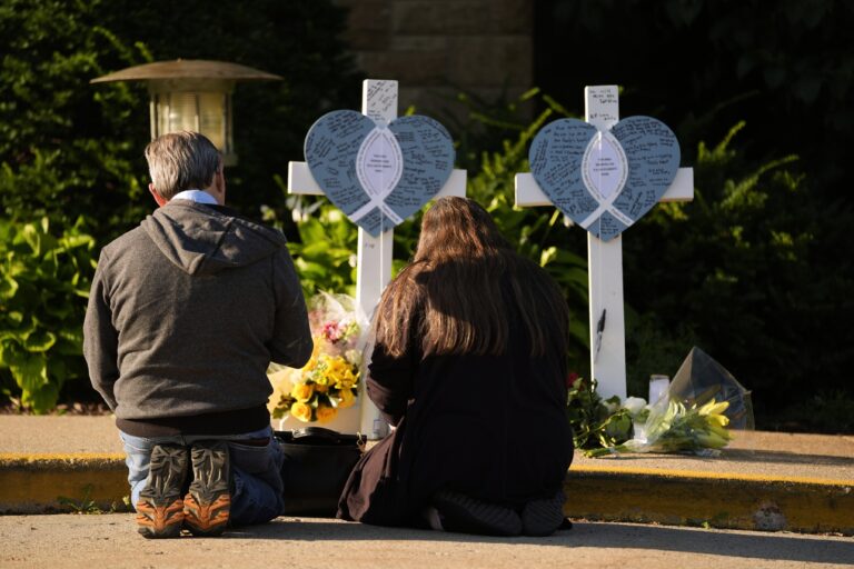 Two people praying at a memorial for slain kids in a Minneapolis school shooting
