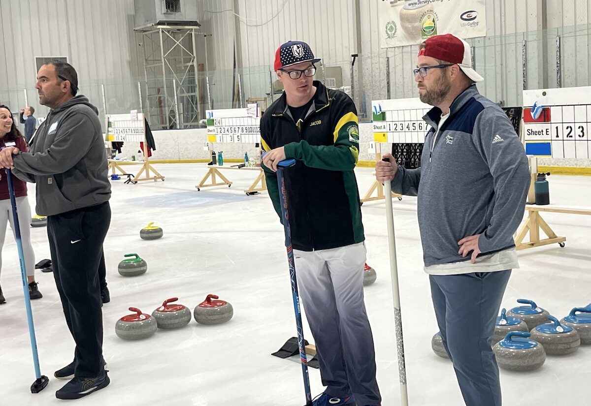 Jacob Boggs [center] talks to curling player