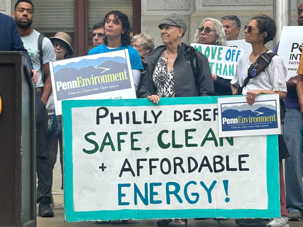 Activists at the rally hold up signs advocating for clean energy