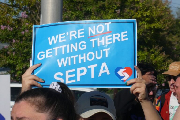 a sign reads WE'RE NOT GETTING THERE WITHOUT SEPTA