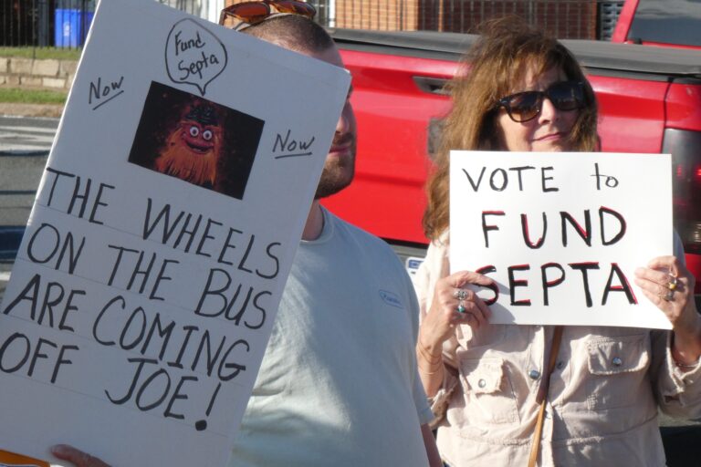 SEPTA rally goers hold signs